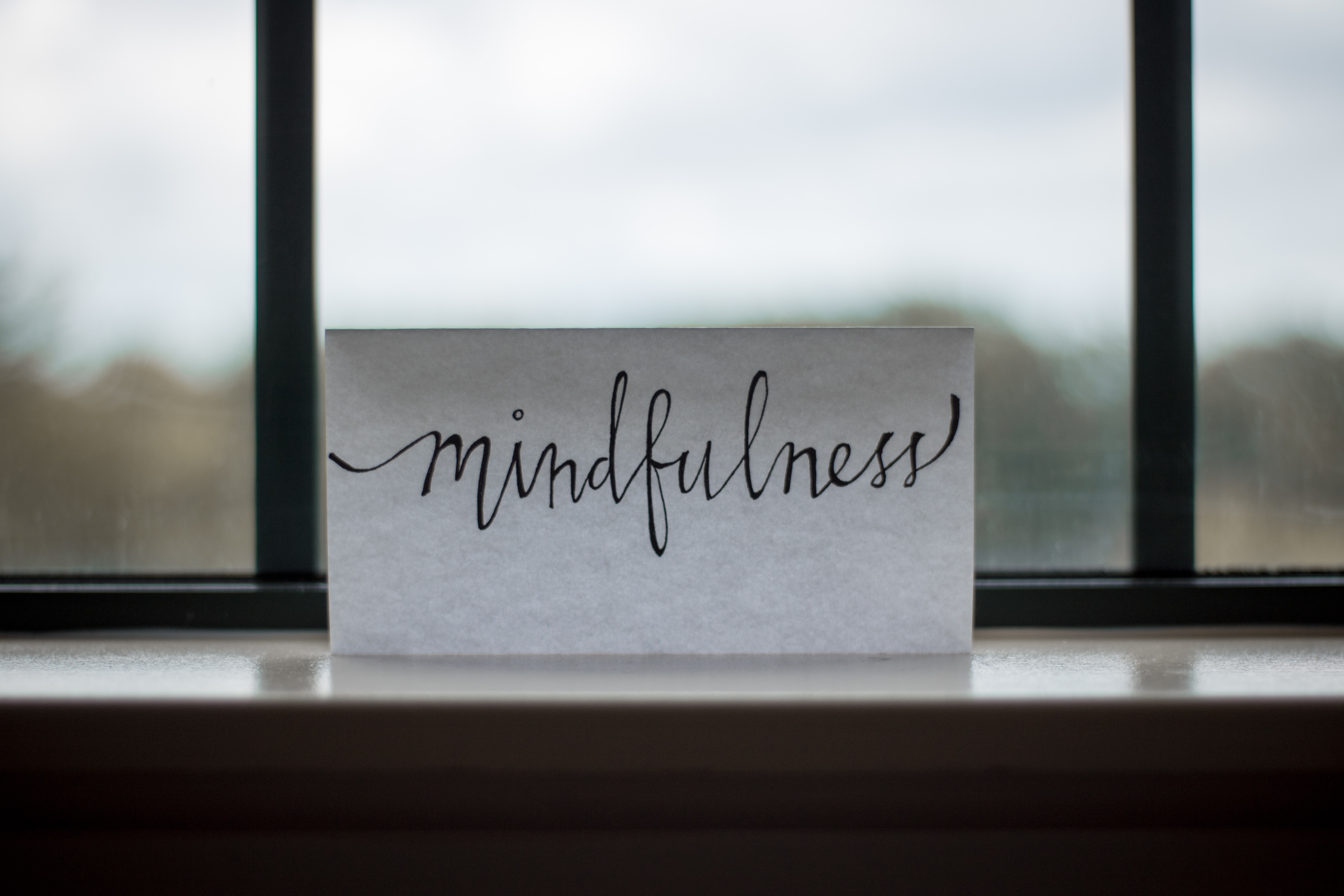 note in front of a window, with nice hand writing saying mindfulness