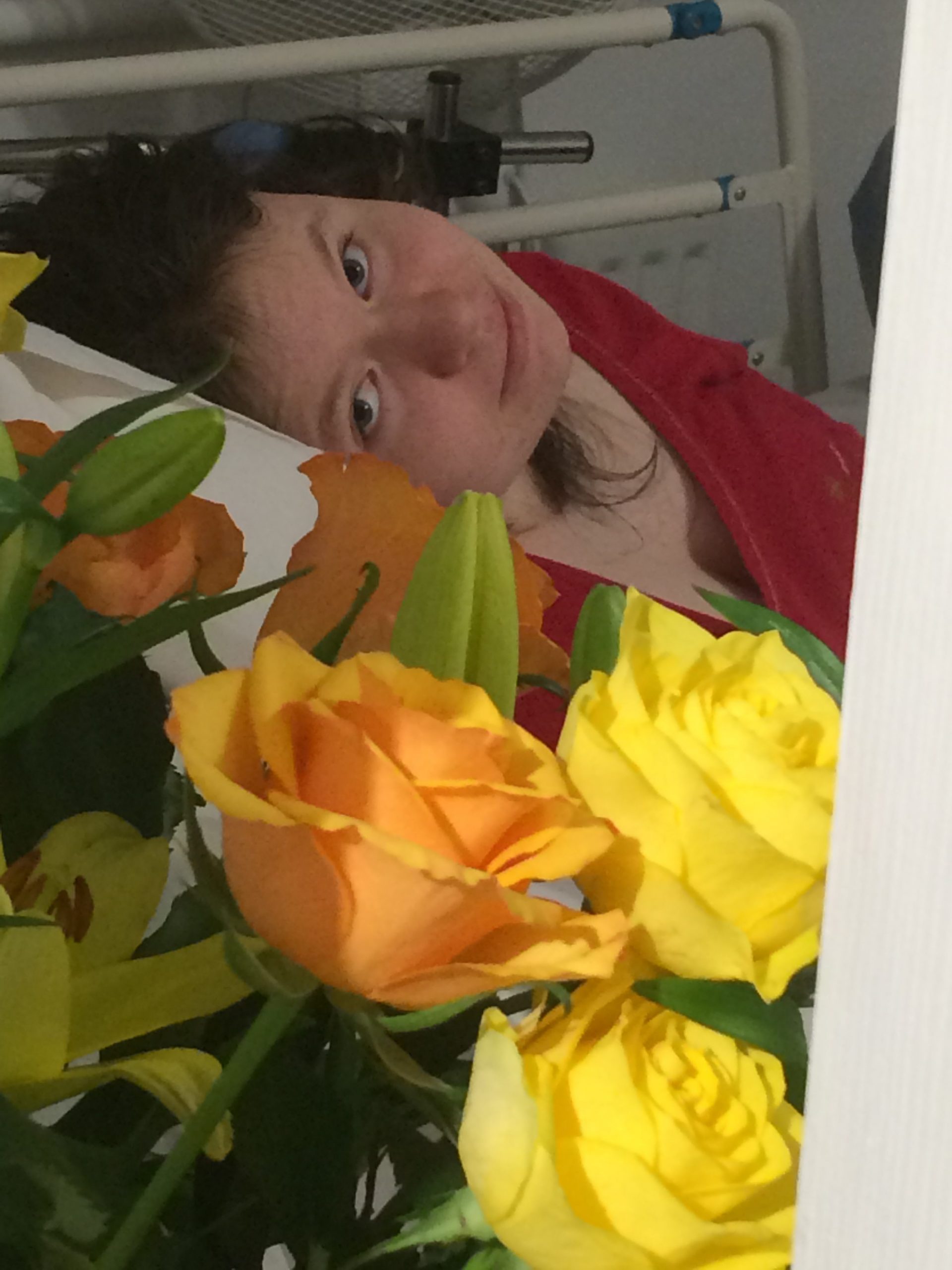 Jade in hospital bed with roses