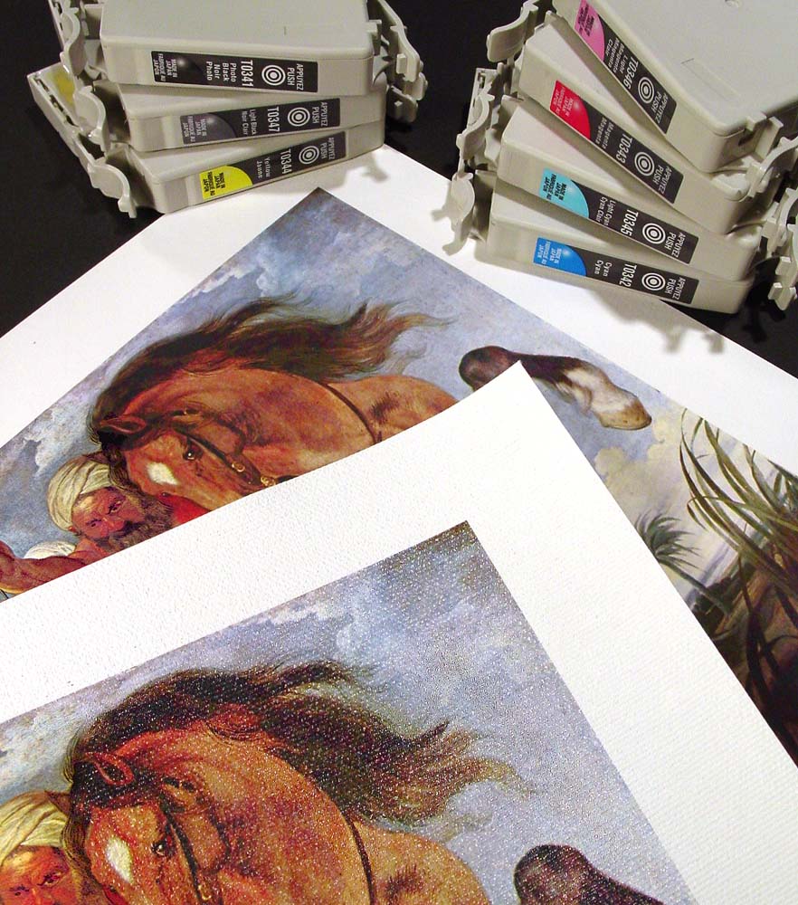 Stack of Giclée prints on a table with ink cartridges